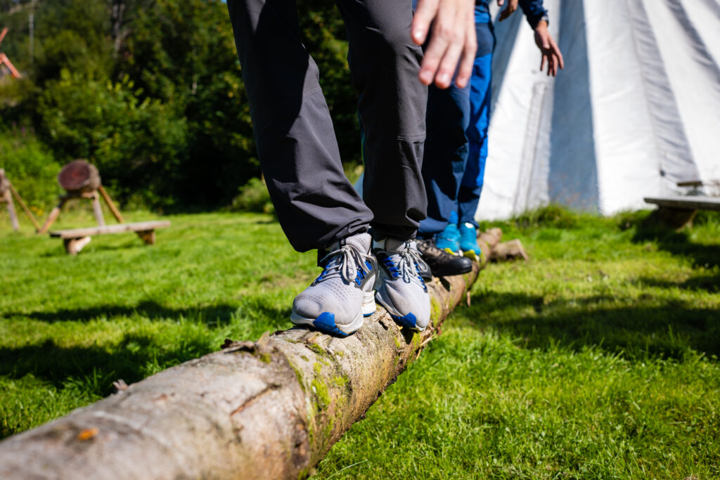 Personer som balanserer på en stokk for å bygge mer samhandling og teambuilding i Bergen